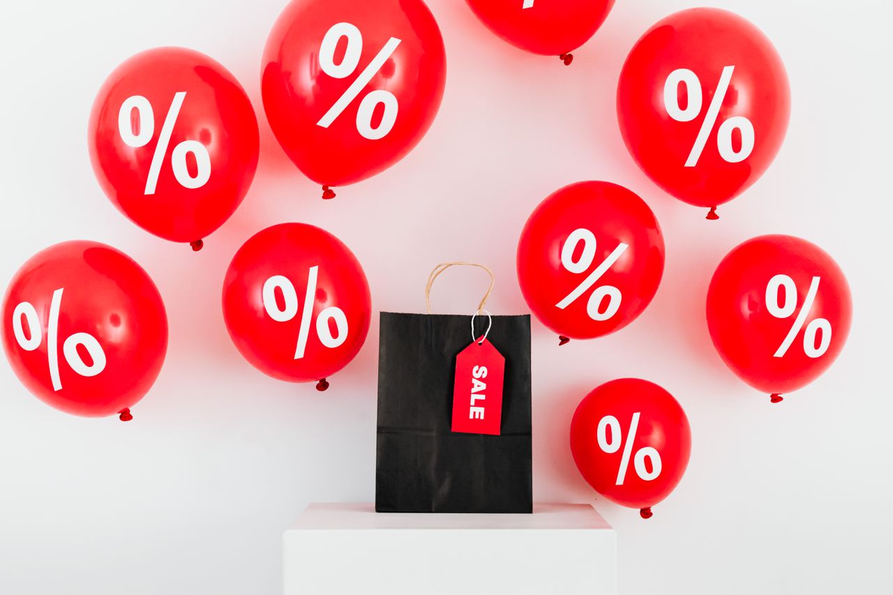 hero-02 Red balloons with percentages and a black sale bag on a white background.